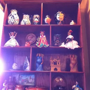 a shelf full of mexican figurines