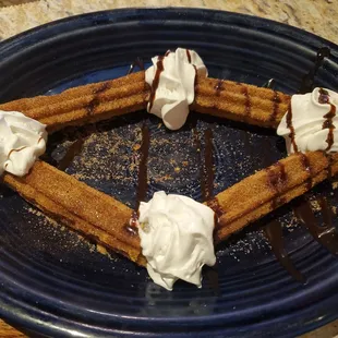 a plate of waffles with whipped cream