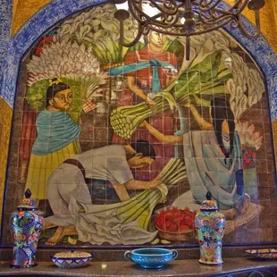 A tile mural of women with flowers.