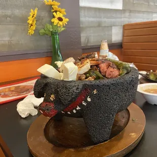 Molcajete: steak, chicken, chorizo, shrimp, sausage and cheese with warm home made tortillas, rice and beans on the side.