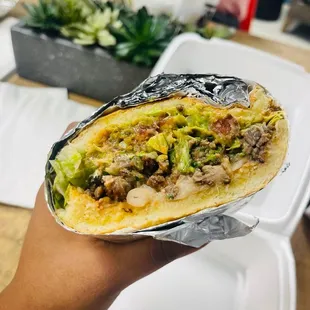 a hand holding a burrito