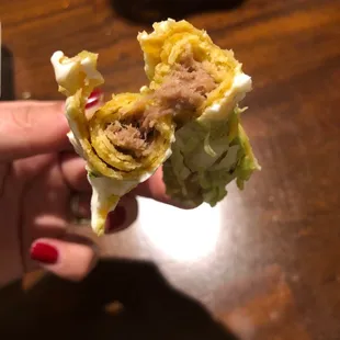 a hand holding a burrito