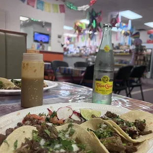 Barbacoa and carne asada tacos with a view of the market