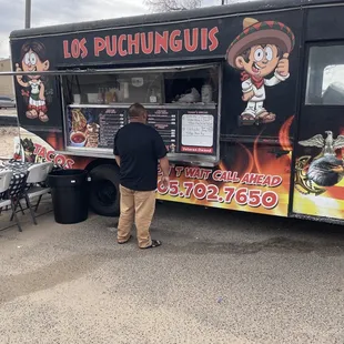 a man standing in front of a food truck