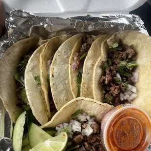 a variety of tacos in a styrofoam container