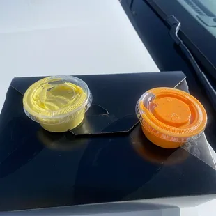 two plastic containers on the hood of a car