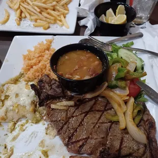Carne Asada, Enchilada con salsa verde, Arroz, ensalada, frijoles Charros, y French Fries