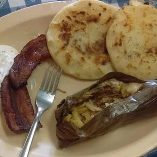 Combo plate with two fried plantains, two pupusas, and a tamale