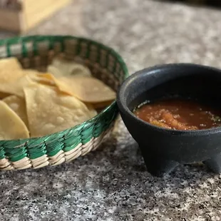 a basket of chips and a bowl of salsa