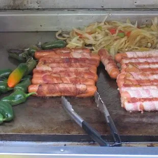 hotdogs and peppers on a grill