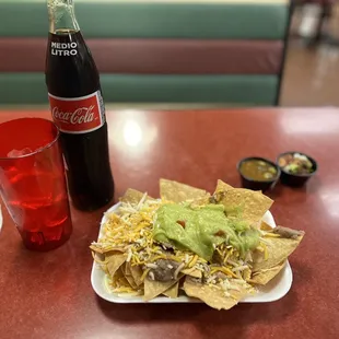 a plate of nachos and a coke