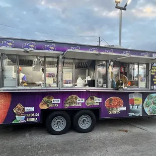 a purple food truck parked in a parking lot