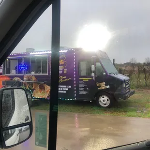 a purple food truck in the rain