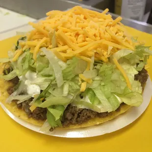 a taco topped with lettuce and cheese