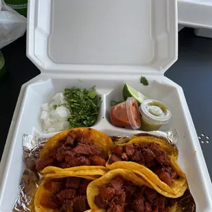 two tacos in a styrofoam container