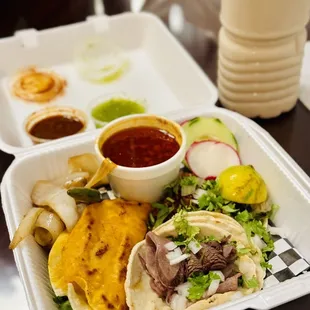 a tray of tacos and salsa