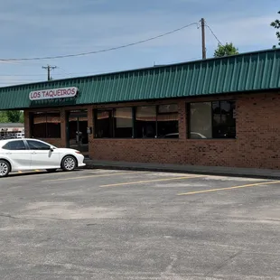 a white car parked in front of a restaurant