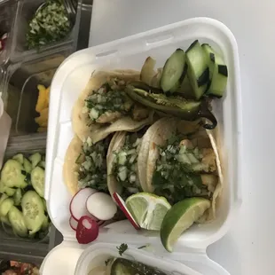 a variety of tacos in plastic containers