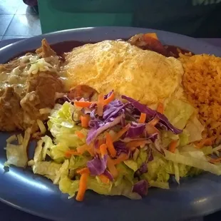 Enchiladas with 2 fried eggs, rice and beans.