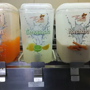 three juice dispensers on a counter