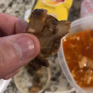 a hand holding a piece of meat