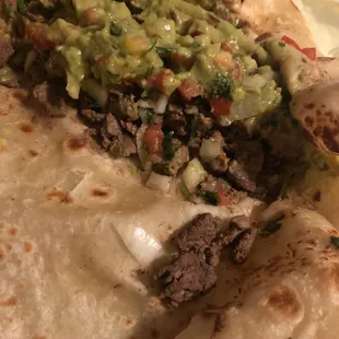 a tortilla with meat and guacamole