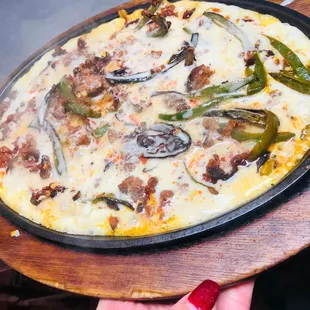 a hand holding a pizza