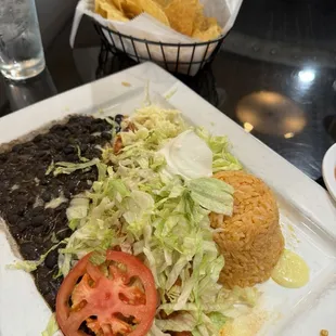 Burrito with rice, black beans, lettuce, tomato, sour cream + chips