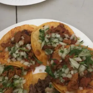 a mix of tacos: asada, cabeza, and pastor