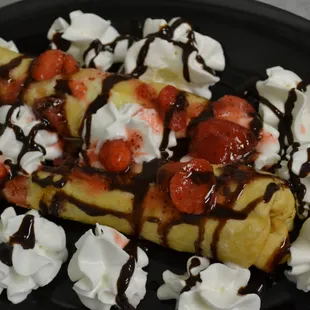a banana split with whipped cream and strawberries