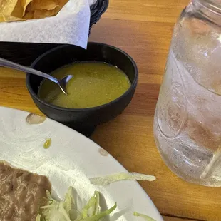 Chips and Green salsa with a large mason jar water.