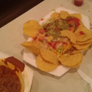 a plate of nachos and a bowl of salsa