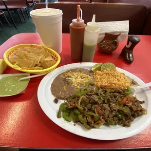 Steak Fajita plate, cooked with bell peppers and onions, served with rice, beans, large tortilla, chips, and home made salsas!