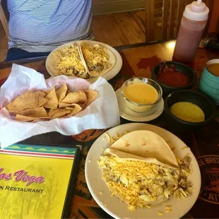 Sausage, egg, and cheese breakfast tacos. Chili con Queso and extra green salsa