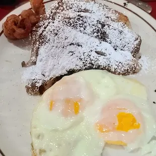 French toast, 2 sunny side up eggs,  and bacon