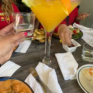 a woman sitting at a table with a drink