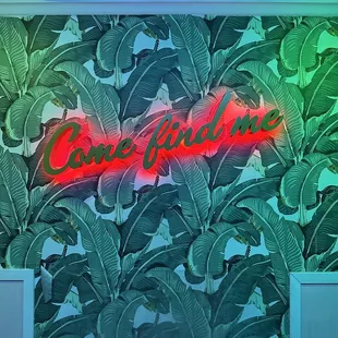 a neon sign in a tropical setting