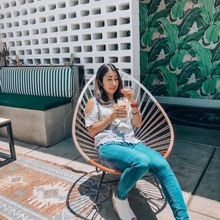 a woman sitting in a chair with a drink