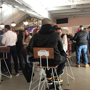 a man sitting on a chair in a crowded restaurant