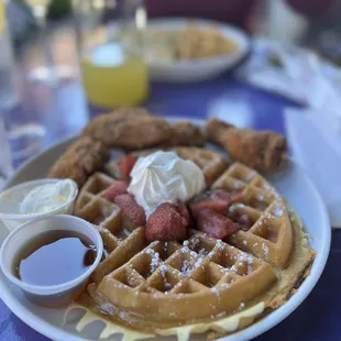 Chicken and waffles with strawberry toppings.