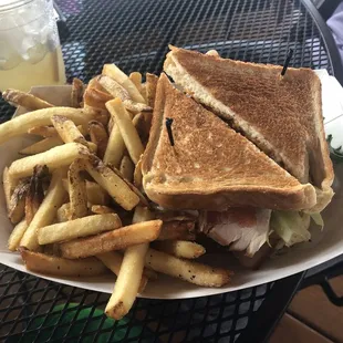 Stacked club sandwich with fries with a almost gone Gold Rush.