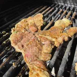 the meat being cooked on the grill