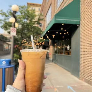 Cold press coffee with caramel in front of the building