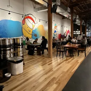 people sitting at tables with beer kegs