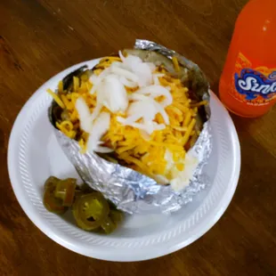 ows a burrito wrapped in foil with cheese and jalapenos