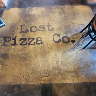 The sign on the floor at the entrance of the restaurant.