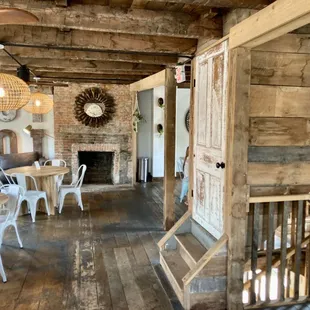a dining room with wood floors and a fireplace