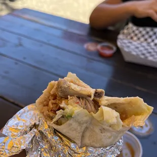 a hand holding a burrito