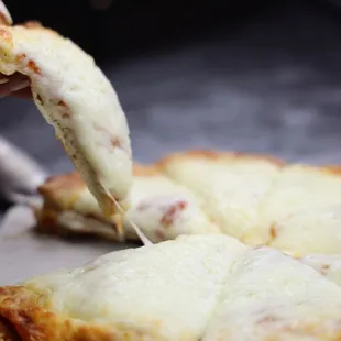 a person taking a slice of pizza