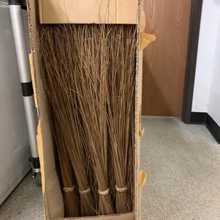 brooms in a cardboard box